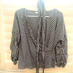 Black/white checked blouse with belt. Puffy, three-quarter length sleeves.